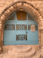 Teal colored door in stone wall