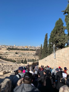 People walking down a road from the Mount of Olives toward the Kidron Valley