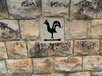 simple painting of a rooster on a stone wall